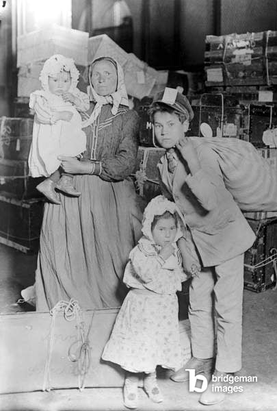 1905 An immigrant family at Ellis Island. Photograph by Lewis W. Hine, c.1905 / Granger / Bridgeman Images