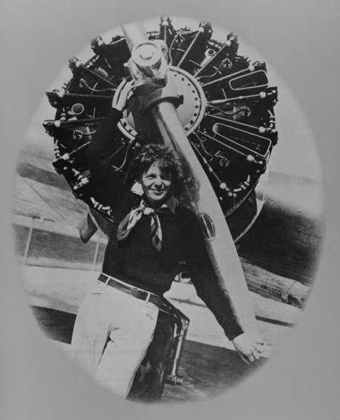 Asset - Amelia Earhart (1897-1937), posting in front of the propeller of her Lockheed L-10E Electra on July 8, 1937, on land during a stop in her final round-the-world flight which began from Miami, Florida, in June 1 