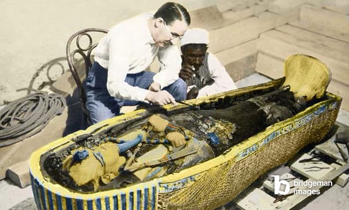 Image of Egypt-1922 : English archaeologist Howard Carter (1873-1939) and an Egyptian assistant examining the sarcophagus of King Tutankhamen, © Stefano Bianchetti / Bridgeman Images